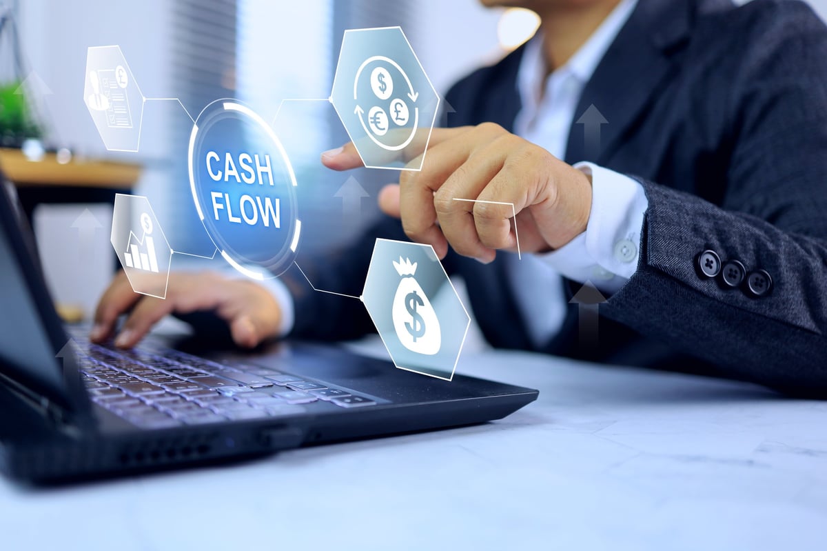 Cash flow concept with businessman working on laptop and pointing on virtual screen on finance icon to show financial agility and efficient investment