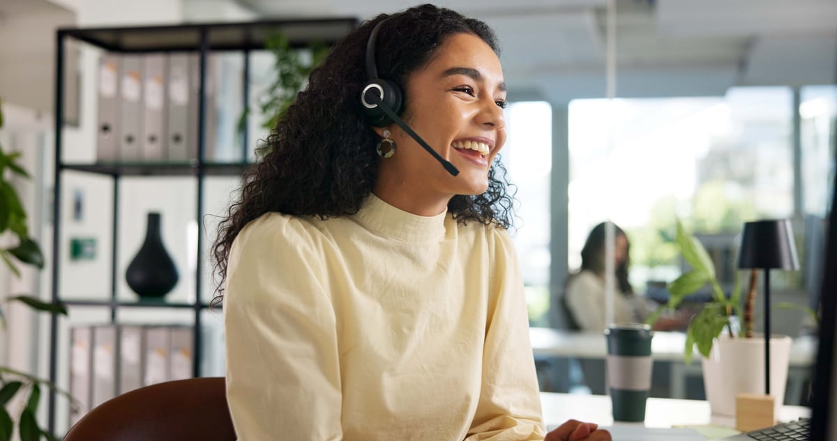 Laughing, happy woman and customer service in call center with agent, communication and online consulting. Friendly consultant and support for business advice or help