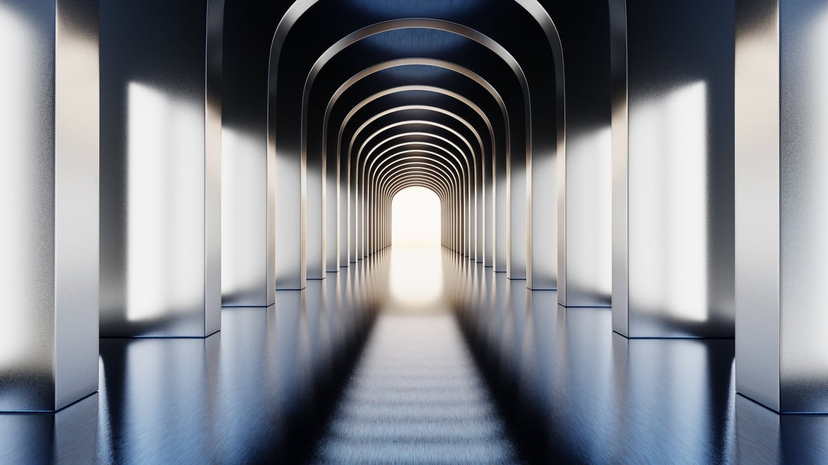 corridor with a series of arches leads to a bright exit. floor reflects light from the walls. space has a modern design and a clean look. light creates depth down the path.