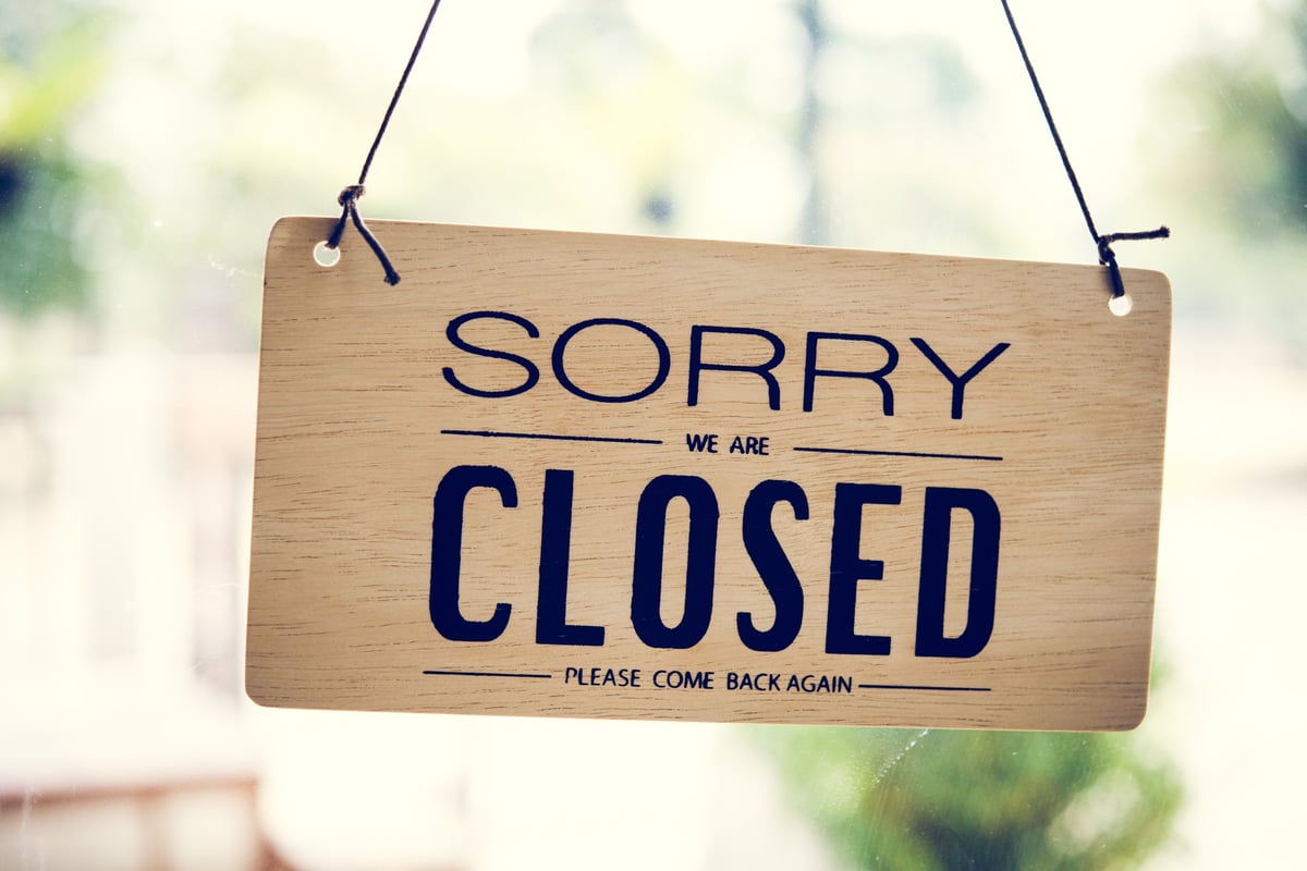 A close-up of a wooden 'Sorry We Are Closed' sign hanging in a shop window. The rustic aesthetic suggests temporary business closure and anticipates future customers. Great for business, retail, or closure-themed designs. Use in blogs, advertisements, or social media to convey a message.