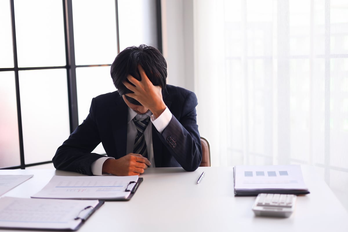 Businessman experiencing stress at work due to heavy workloads, financial worries, and the pressure of responsibility.